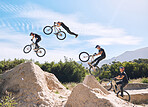 Young man showing his cycling skills while out cycling on a bicycle outside. Adrenaline junkie practicing a dirt jump outdoors. Male wearing a helmet doing extreme sports with a bike. Phases of a jump
