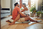 Happy caucasian couple being affectionate and enjoying romantic intimate moment while sitting on living room floor. Young woman sitting on top of boyfriend and putting her arms around him