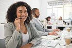 Portrait of a young happy mixed race female call center agent answering calls while wearing a headset at work. One hispanic businesswoman with a curly afro talking on a call at a desk in an office