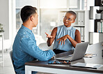 Two businesspeople having a meeting together in an office at work. Young african american businesswoman talking to an asian businessman. Colleagues planning at work