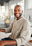 Portrait of a young cheerful african american businessman sitting at a desk alone at work. One joyful and positive male businessperson smiling while working in an office