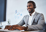 One happy young african american call centre telemarketing agent talking on a headset while working on computer in an office. Confident friendly male consultant operating helpdesk for customer service and sales support