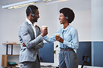 Two happy young african american call centre telemarketing agents having a chat while drinking coffee and laughing together during lunch break in an office