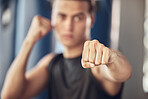 Closeup on the hand of an athlete. Boxer punching in the gym. Strong bodybuilder boxing in the gym. Active fit man throwing a punch in the gym. Strong boxer training in the gym