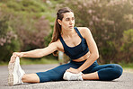 One fit young mixed race woman touching her feet and stretching legs for warmup to prevent injury while exercising outdoors. Female athlete preparing body and muscles for training workout or run at the park