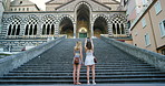 Two friends using their cellphones to take photos of a church in Italy. Two friends on holiday taking photos