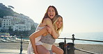 Cheerful women playing and giving one another piggyback rides during a holiday